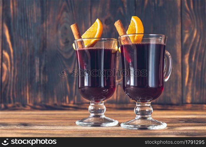 Glasses of mulled wine garnished with cinnamon and orange