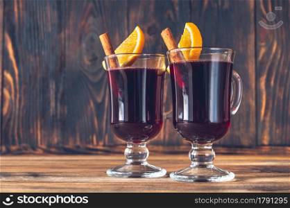 Glasses of mulled wine garnished with cinnamon and orange