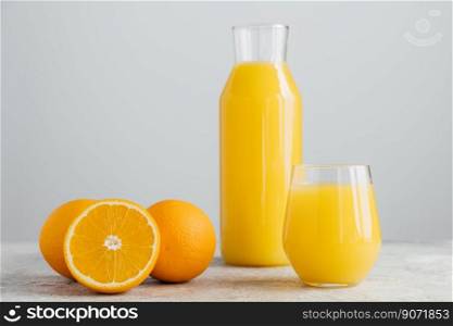Glasses of orange juice, sliced fresh oranges on white background. Horizontal composition. Delicious fruit and drink. Citrus around