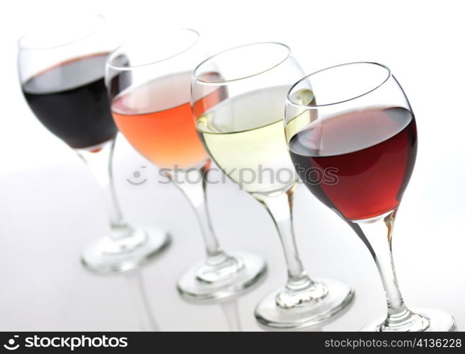 glasses of pink , red and white wine on white background