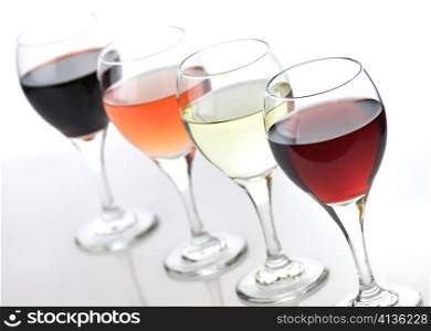 glasses of pink , red and white wine on white background