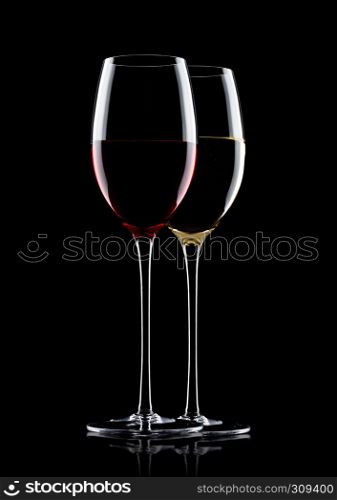 Glasses of red and white wine on black background with reflection