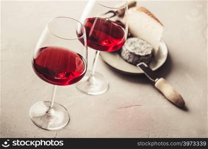 Glasses of Red wine and cheese on concrete background. Red wine and cheese on concrete background