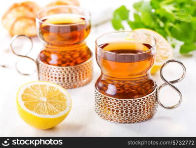 glasses of tea with lemon on wooden table
