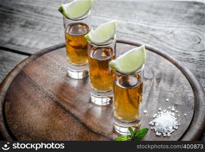 Glasses of tequila on the wooden board