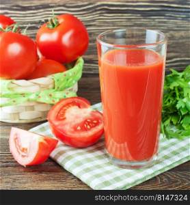 Glasses of tomato juice and fresh tomatoes on brown wooden table. tomato juice and fresh tomatoes on wooden table