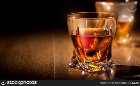 Glasses of whiskey on a wooden table