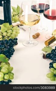 Glasses of white, red and rose wine and grapes over white background