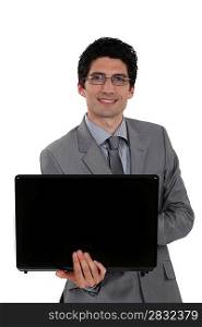 Glasses wearing businessman holding laptop