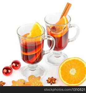 Glasses with mulled wine, orange, spices and gingerbread cookies isolated on a white background.
