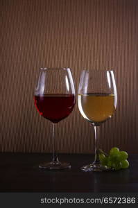 glasses with red and white wine on table, low key dark image. Glass of red wine