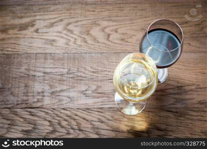 Glasses with red and white wine on the wooden background