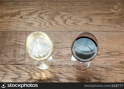 Glasses with red and white wine on the wooden background