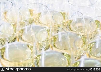 glasses with white wine in rows at party table. glasses with cognac or brandy