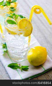 Glasss of mojito with lemon and drinking straw