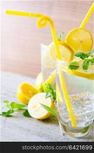 Glasss of mojito with lemon and drinking straw