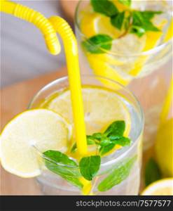 Glasss of mojito with lemon and drinking straw. The glasss of mojito with lemon and drinking straw