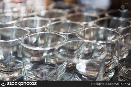 glassware, dishware and alcohol concept - close up of empty clean whiskey glasses set at restaurant or bar