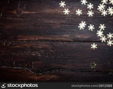 Glitter golden snowflakes on grunge wood background. Holiday Background