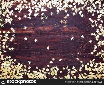 Glitter golden stars on grunge wood background. Holiday Background