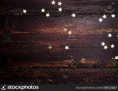 Glitter golden stars on grunge wood background. Holiday Background