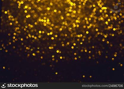 Glitter lights defocused abstract bokeh background. Shiny gold glitter festive stars bokeh.