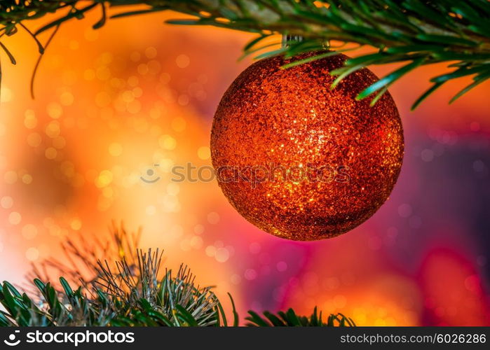 Glittering Christmas bauble in red color on a tree