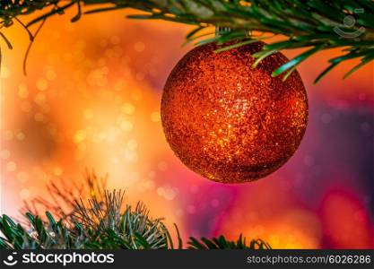 Glittering Christmas bauble in red color on a tree
