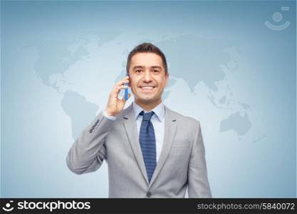 global business, people, communication and technology concept - happy businessman calling on smartphone over blue background with world map