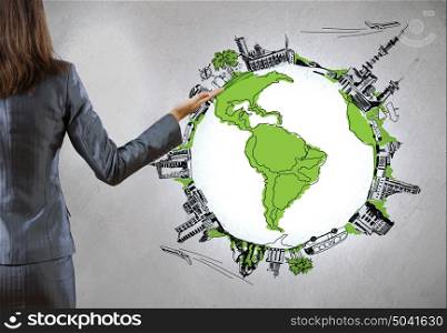 Global business. Rear view of businesswoman presenting drawn Earth planet