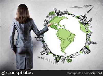 Global business. Rear view of businesswoman presenting drawn Earth planet