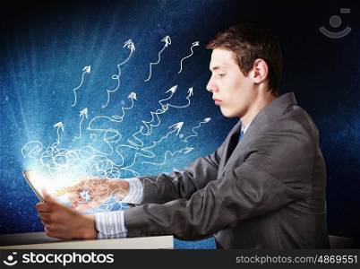 Global business. Young confident businessman sitting at table using tablet pc