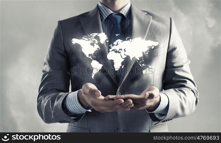 Global interaction. Close up of businessman holding world map in hands