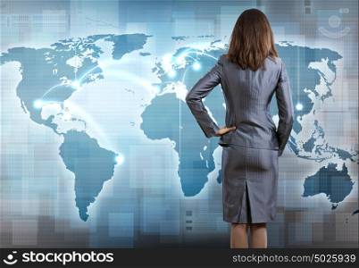 Global interaction. Rear view of businesswoman pointing at world map