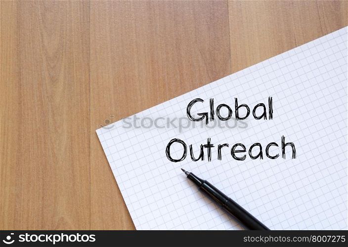 Global outreach text concept write on notebook with pen