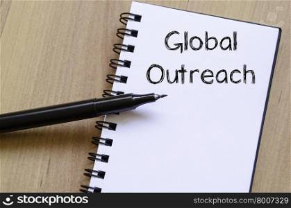 Global outreach text concept write on notebook with pen