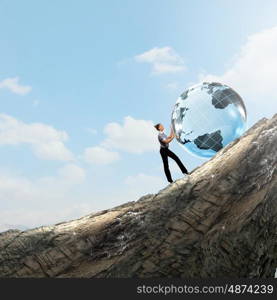 Global technologies. Young businesswoman rolling Earth planet up th hill