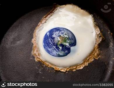 Global warming concept image with the world being fried in a frying pan like an egg.