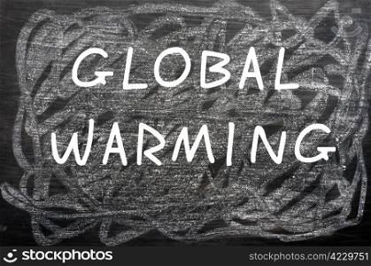 ""Global Warming" written with white chalk on a smudged chalkboard "