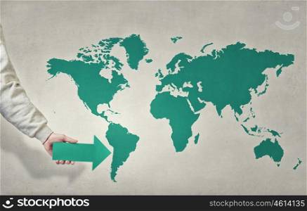 Globalization concept. Close up of hand pointing with arrow at world map