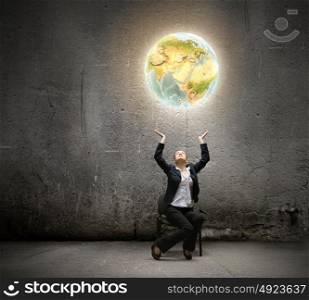 Globalization concept. Image of businesswoman holding earth planet in hands above head. Elements of this image are furnished by NASA