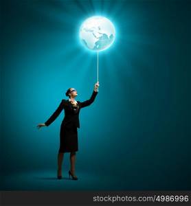 Globalization concept. Image of businesswoman in goggles holding globe balloon