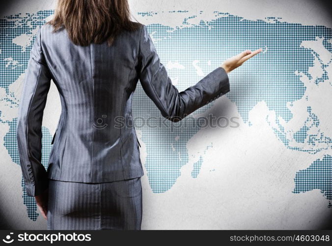 Globalization concept. Rear view of businesswoman and world map at background