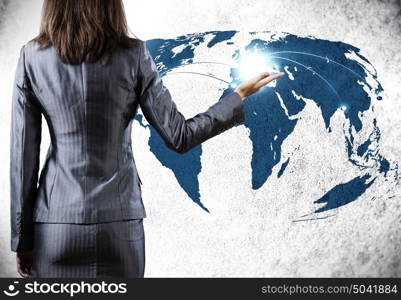 Globalization concept. Rear view of businesswoman and world map at background
