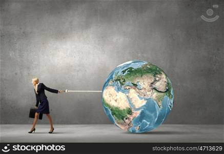 Globalization concept. Young businesswoman holding Earth planet on lead. Elements of this image are furnished by NASA