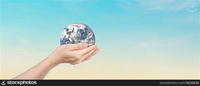 Globe in hands over blue sky background. Save of earth. Elements of this image furnished by NASA