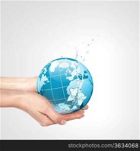 Globe in human hand against blue sky. Environmental protection concept. Elements of this image furnished by NASA