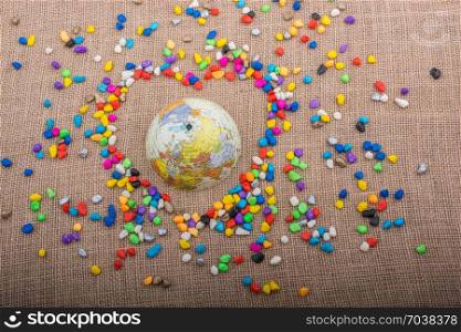 Globe in the heart form shaped by colorful pebbles