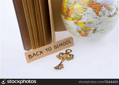 Globe, key and back to school title on a notebook
