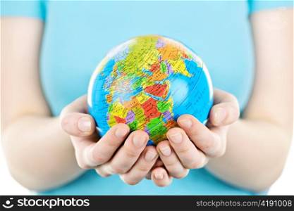 Globe of the planet Earth held in young female hands